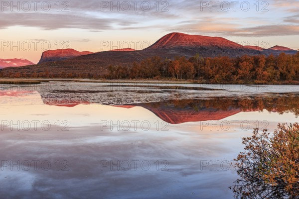 Mountains reflected in lake, autumn colours, cloudy mood, morning light, dawn, Nikkaluokta, Laponia, Lapland, Sweden, Europe