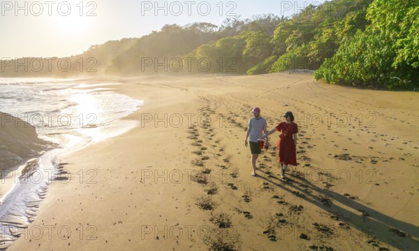 Two tourists walking on the sandy beach, Playa Cocalito, Puntarenas, Costa Rica, Central America