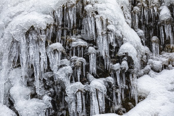 Icicles on the rock face at Skogafoss waterfall, Sudurland, Iceland, Europe