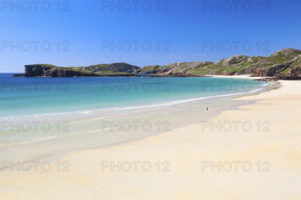 Lonely person on the idyllic sandy edge of Oldshoremore, on the west coast of Scotland
