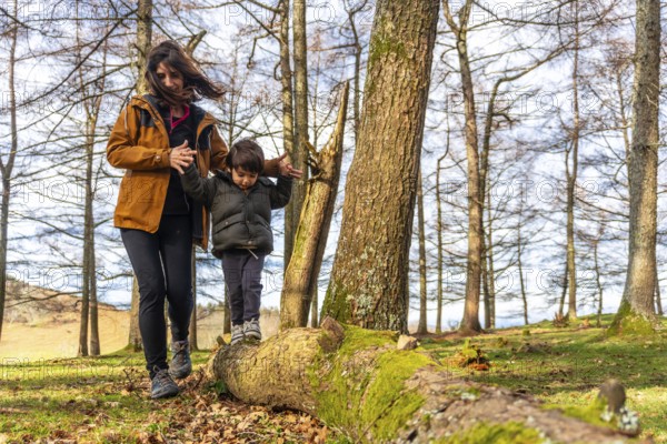 Mother with her son walking in a tree in a forest very happy on Mount Erlaitz in Irun, Basque Country