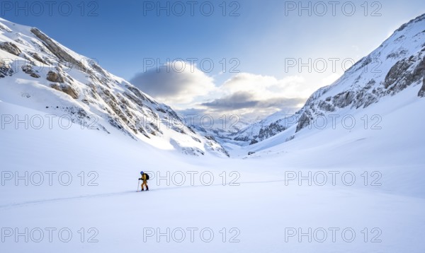 Ski tourers ascending through untouched fresh snow, snow-covered mountain landscape with blue sky and clouds, ski tour on the Wildhorn, Bernese Alps, Switzerland, Europe