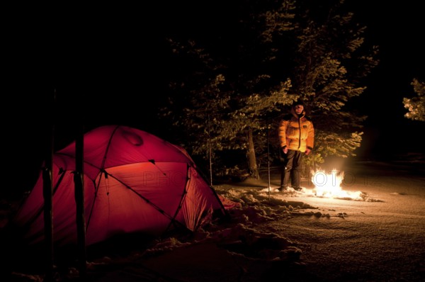 Tent in mountain landscape, Sarek National Park, Laponia World Heritage Site, Norrbotten, Lapland, Sweden, man warming himself by the campfire, Scandinavia, Europe