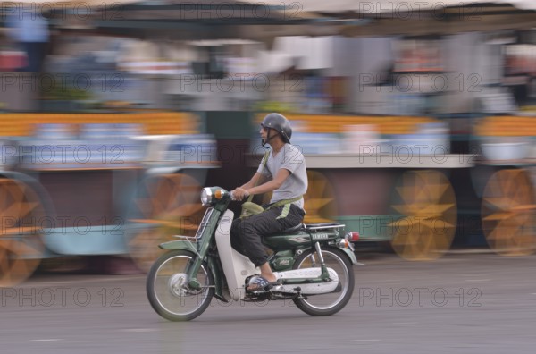 Moped rider at Djemaa el Fna market square, historic center, Marrakesh, Marrakesh-Tensift-El Haouz region, Morocco, Africa