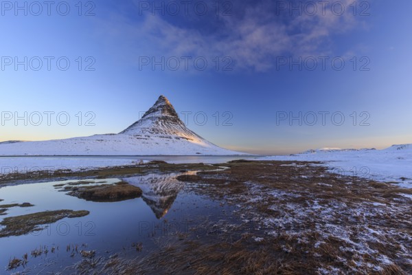 Pointed mountain reflected in fjord at low tide, snow, winter, morning light, Kirkjufell, Snaefellsnes, Iceland, Europe