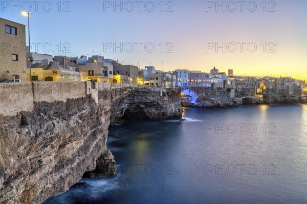 Polignano a Mare with its houses directly on the cliffs after sunset