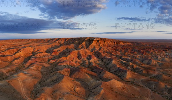 Aerial panorama of textural colorful striped canyons Tsagaan suvarga, White stupa at sunrise. Ulziit soum, Dundgovi province, Mongolia, Asia