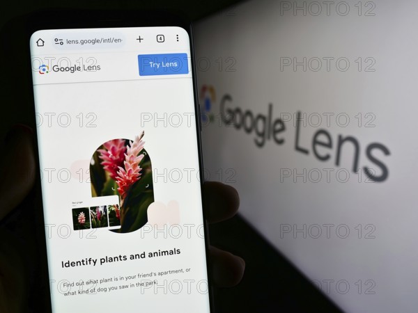 Stuttgart, Germany, 09-23-2023: Person holding smartphone with webpage of image recognition app Google Lens on screen in front of logo. Focus on center of phone display, Europe