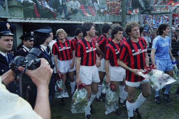 Angelo COLOMBO AC Milan, Mauro TASSOTTI AC Milan hidden, Carlo ANCELLOTTI AC Milan, Paolo MALDINI AC Milan looking from behind, Roberto DONADONI AC Milan and captain Franco BARESI AC Milan, all AC Milan players with bouquets of flowers for the fans, on the left are three policemen and a camera in the hands of a photographer, Sinigaglia football stadium, Como, football match, the 1987/88 AC Milan championship team in front of the decisive match of the championship in Italy, from left to right.l.t.r
