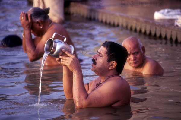 A Pilgrim pays homage to the Mother of River Ganga Ganges Ghats at Varanasi Benaras, Uttar Pradesh, India, Asia