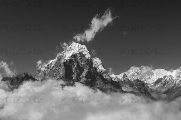 Taboche Peak (6505 m) of the Khumbu Region. Cho Oyu, the eight-thousander and the sixth-highest mountain in the world, is in the background. View from the moraine high above the Ama Dablam Base Camp. Monochrome, greyscale photograph. Everest Region, Himalayas, Sagarmatha National Park, the UNESCO World Heritage Site. Solukhumbu, Nepal, Asia