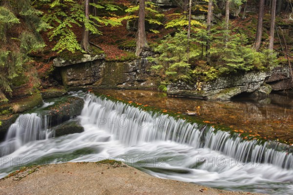 Water cascade on szklarka stream in autumn forest of Karkonoski National Park, Karkonosze Mountains, Lower Silesia, Poland, Europe