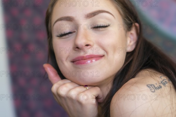A beautiful brunette model smokes marijuana in the privacy of her own home