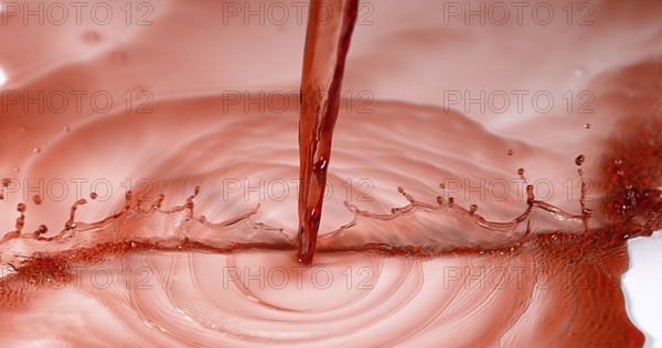 Red Wine being poured against White Background