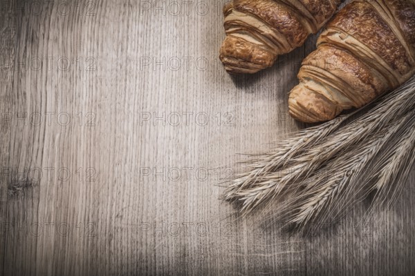 Wheat rye ears croissants on wooden board