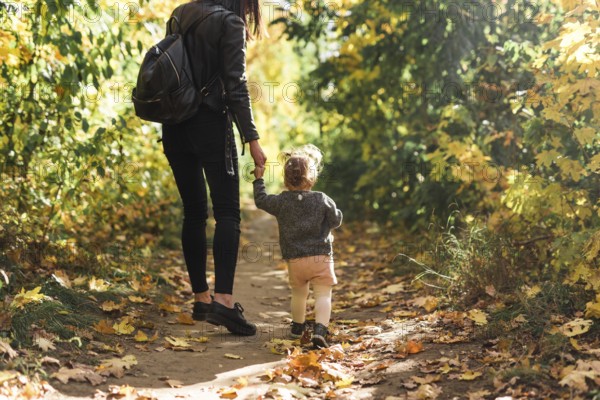 Rear view mother daughter walking forest