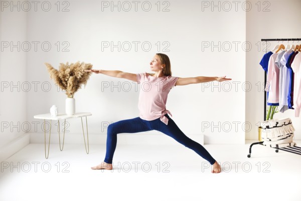 Calm female in sportswear practicing yoga in pose while balancing and looking away