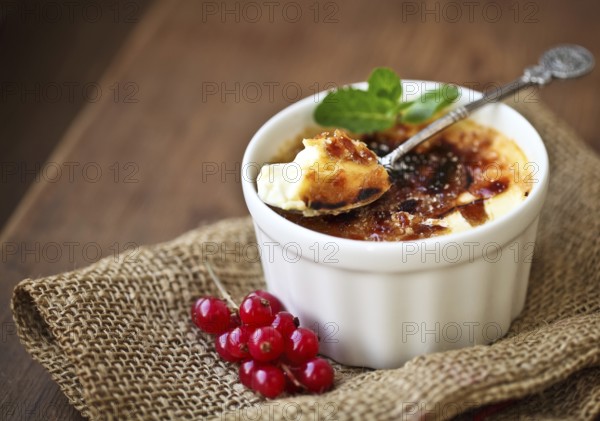 Creme brulee (cream brulee, burnt cream) with red currant and mint