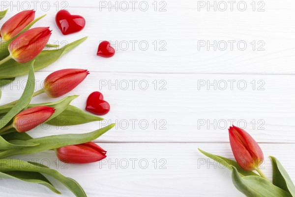 Red tulip bouquet and heart on wooden table with copy space