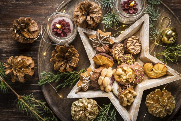 Variation of Christmas cookies and gingerbread with ornaments on wooden background