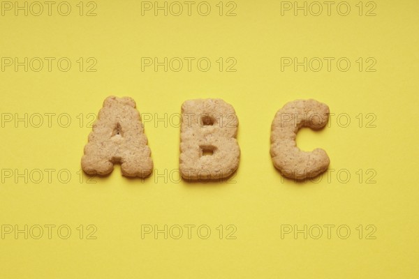ABC cookie or biscuit letters or characters on yellow paper background