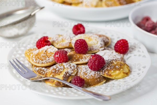 Poffertjes - small Dutch pancakes with fresh raspberries. Traditional Dutch cuisine
