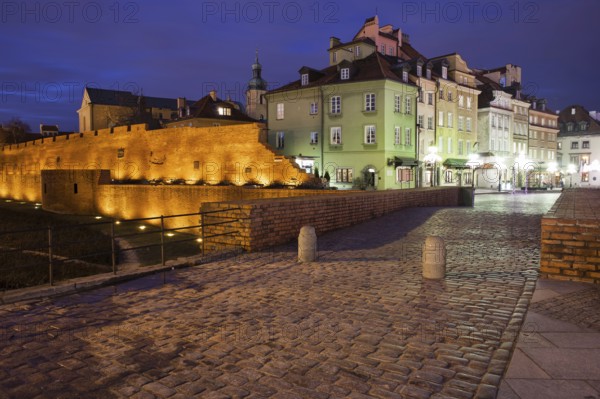 Warsaw Old Town skyline by night in Poland, fortified city wall, historic tenement houses