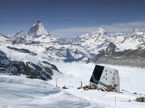 view of the Monte Rosa mountain hut and Gorner Glacier with the Matterhorn behind in the Valais region above Zermatt