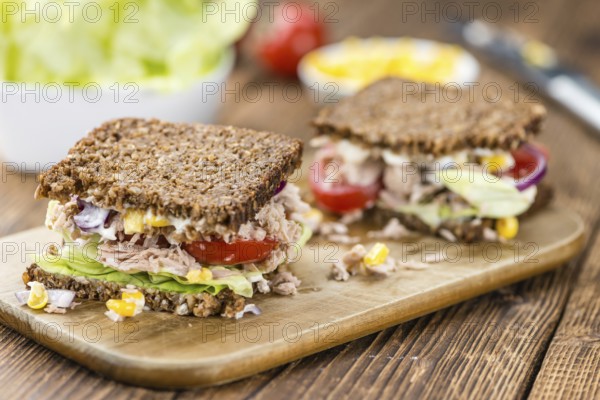 Old wooden table with Tuna sandwich (on wholemeal bread, selective focus)