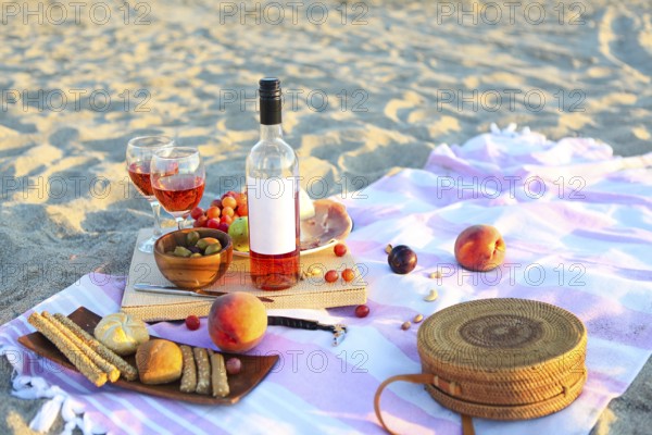 Picnic outdoor with rose wine fruits meat and cheese. Sunset