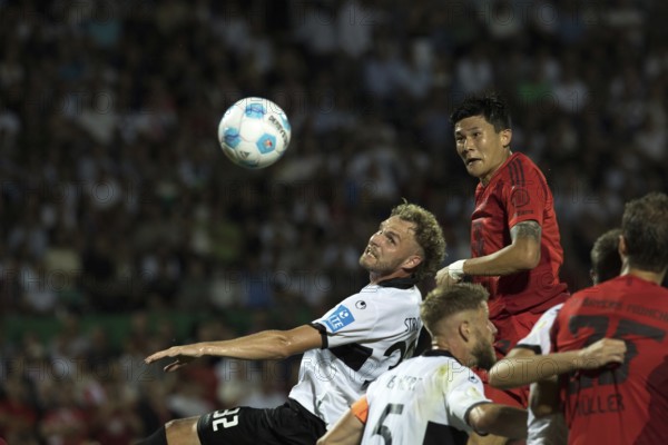 Football match, Minjae KIM FC Bayern Munich right heads the ball after a cross, Philipp STROMPF SSV Ulm tries to stop him, Donaustadion football stadium, Ulm, Germany, Europe