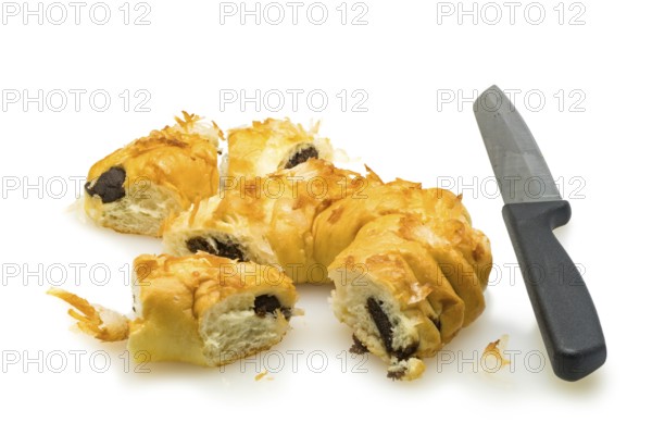 Pieces of bread pudding with coconut and knife on white background