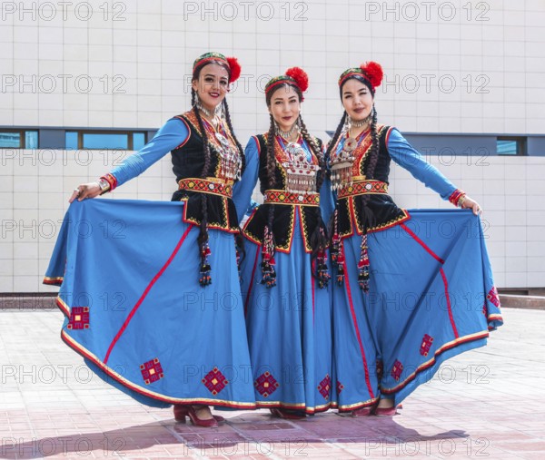 NUKUS, UZBEKISTAN - MAY 6, 2019: Three traditionally dressed folk dancers in Nukus, Uzbekistan, Asia