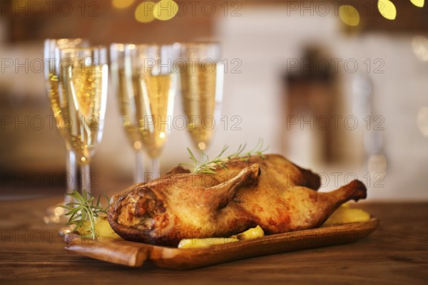 Christmas dinner with roast duck and champagne on wooden table
