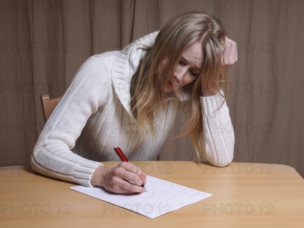 lovesick young woman writing letter with broken heart