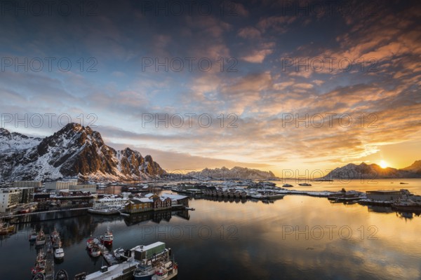 View over the port of Svolvaer on the Lofoten islands in colorful early morning sunrise in winter with snow