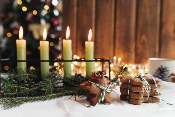 Christmas decorations with candles, fir branches and gingerbread.