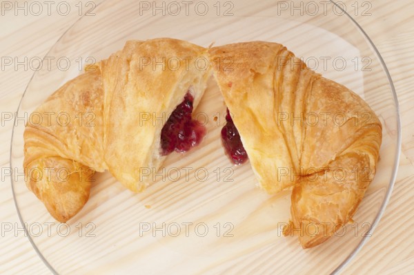 Fresh baked croissant French brioche filled with berries jam