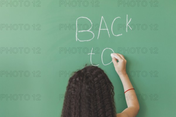 Brunette girl standing chalkboard writing