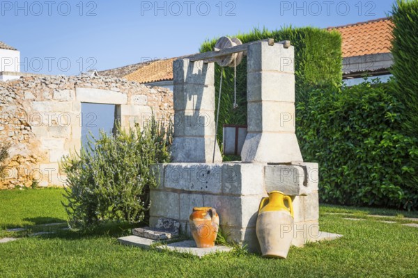 Summer season in Italy. Desing water well in an elegant garden