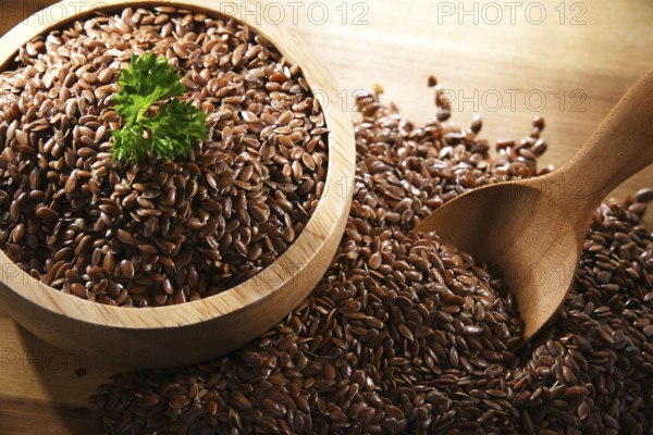 Bowl of brown flax seeds on wooden table