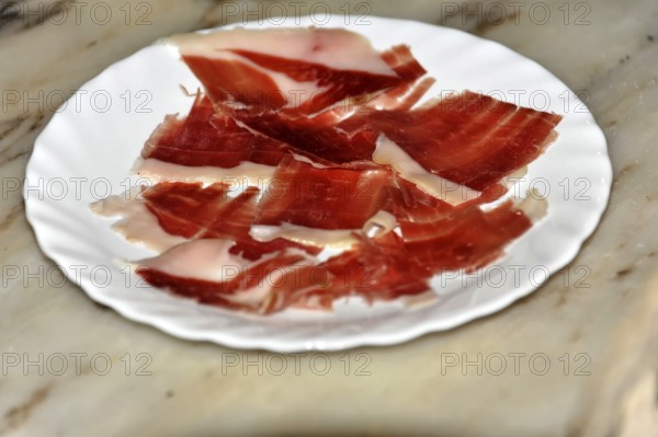 At Arcos, slices of pink ham served on a white plate, Andalusia, Spain, Europe