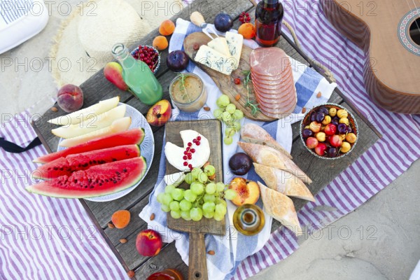 Picnic on the beach at sunset in the style of boho. Food and drink, relax, holiday concept