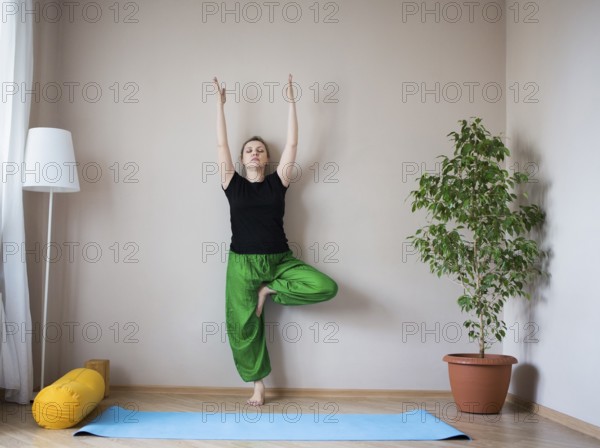 Middle aged or mature woman doing yoga indoors