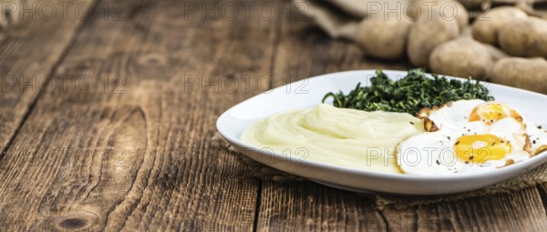 Portion of homemade Mashed Potatoes on wooden background (selective focus, close-up shot)