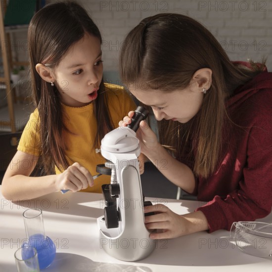 Medium shot girls learning with microscope