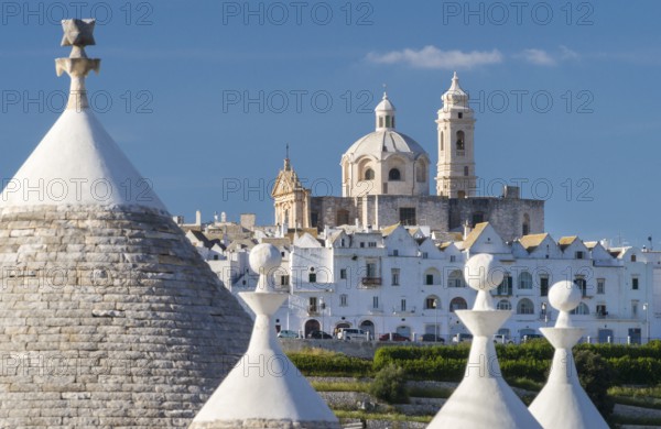 View through trulli, round conical houses, to Locorotondo with the neoclassical church San Giorgio Martire 1790-1825, Locorotondo, Valle d?Itria, Apulia, Puglia, Italy, Europe