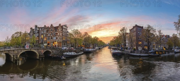 Amsterdam Netherlands, sunset panorama city skyline at canal waterfront