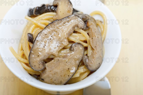 Italian spaghetti pasta and fresh wild mushrooms on rustic wood table