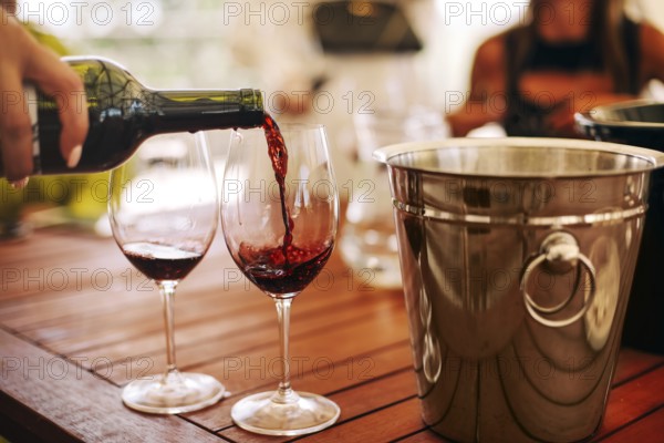 Glasses with different types of wine and human hands holding wine glasses in the background. Degustation wine